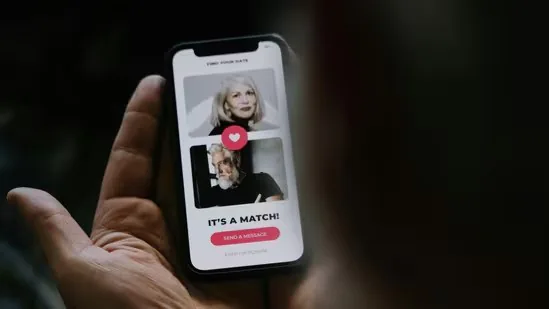 A hand holding a phone showing a dating app's “It’s a match!” screen