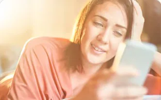 A woman smiling at her phone
